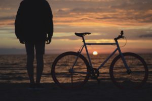 Biker on the beach overlooking the sunset