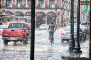 Electric Bike Vs Car: Man biking in the rain